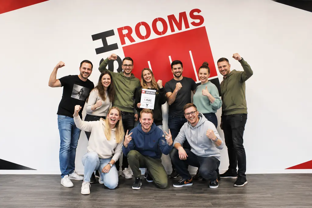 Eine Gruppe jubelt mit erhobenen Fäusten, vorne hocken einige mit Urkunden