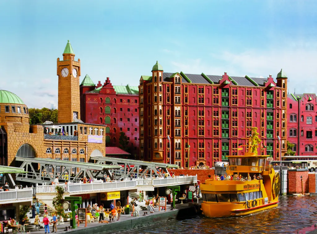 Anlagenabschnitt Hamburg: Landungsbrücken mit Uhrturm, Speicherstadt-Fassaden und gelber Hafenfähre bei Tageslicht