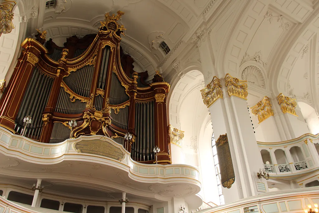 Innenraum des Michel mit der Großen Orgel, weißen Emporen und goldenem Stuck, menschenleer