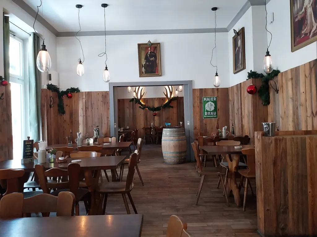 Leere, holzvertäfelte Gaststube des Wirtshauses Hohenwart mit Hängelampen und Bierfass